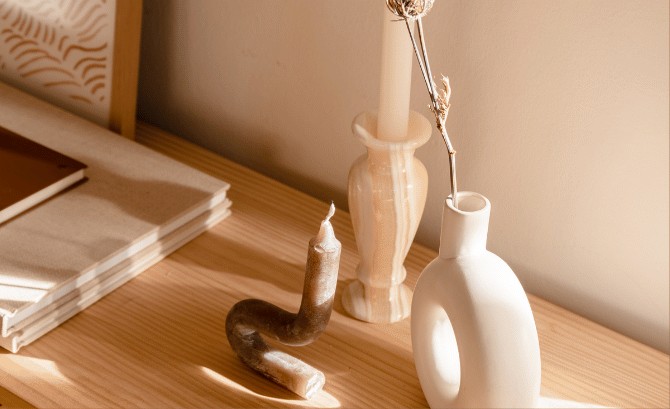 Warm, minimal interior styling with vases and a candle on a wooden table